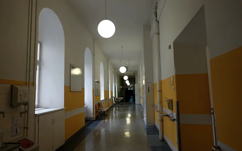 Clean clinic corridor with hard floors and handrails