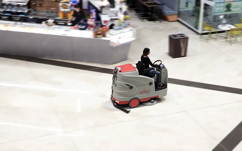 Ride-on floor scrubber working a large hard floor